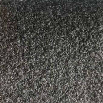 Dark gray rug with dense looped fibers, likely wool or blend, displaying a consistent charcoal tone and plush, textured pile throughout.